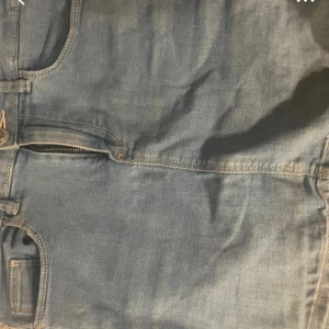 Ljusblå jeanskjol med fickor - Säljer en ljusblå jeanskjol från Your Denim Your Rules i storlek 158/164. Kjolen har klassisk femficksdesign, bälteshällor och dragkedja framtill. Perfekt för dig som gillar en enkel och stilren denimlook.