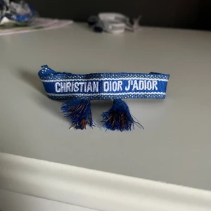Blått och guldigt Christian dior armband - Snyggt blått/guldigt armband från Christian Dior med justerbara tofsar. 130kr inga prisförslag!