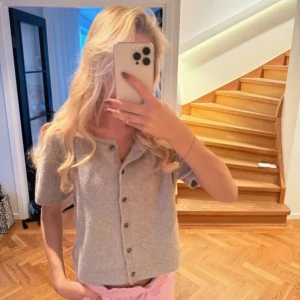 Beige kortärmad kofta med knappar - Supermysig beige kofta med korta ärmar och rund hals. Den är stickad i mjukt material och har snygga knappar framtill. Tröjan är helt ny och oanvänd💓💓