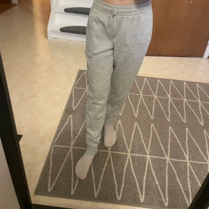 Grå mjukisbyxor från Frank Dandy XS - Grå mjukisbyxor från Frank Dandy i modellen Andy. Byxorna har resår och snörning i midjan samt muddar vid bensluten. Tillverkade i mjukt material som är perfekt för chill dagar. Snygg och enkel design som passar till allt.