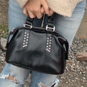 Svart handväska i skinn med nitar - Cool svart handväska i glansigt skinn med dubbla handtag och snygga nitar på remmarna. 💕💕💕