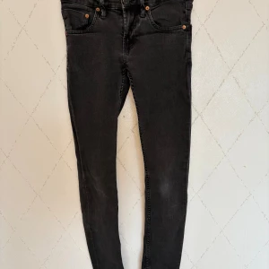 Svarta skinny jeans från 157, XS - Svarta jeans från 157 i storlek XS med klassisk femficksdesign och smal passform. Jeansen har knapp och dragkedja framtill samt raka bakfickor. Materialet är mjukt och stretchigt jeans-tyg som sitter tajt längs benen.