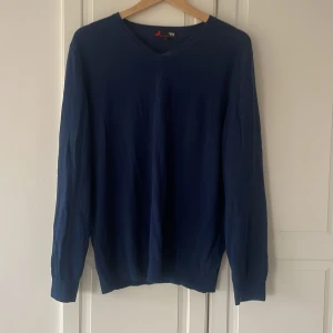 Mörkblå merinoullströja  - Säljer en stilren mörkblå tröja från Dressmann i mjuk merinoull. Tröjan har v-ringning, och i storlekn L