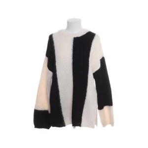 Svartvit randig stickad tröja ASOS - Snygg stickad tröja från ASOS DESIGN i storlek S. Tröjan har breda svarta och vita ränder, rund hals och långärmad passform. Materialet är mjuk och fluffig polyester som ger en cozy vibe. Perfekt för dig som gillar statement-plagg med grafisk look.