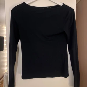 Svart långärmad topp från 157 - En basic svart långärmad topp från 157 i storlek XS. Toppen har en enkel och stilren design med rund halsringning och är tillverkad i mjukt bomullsmaterial. Perfekt att matcha med jeans eller kjol för en clean look.