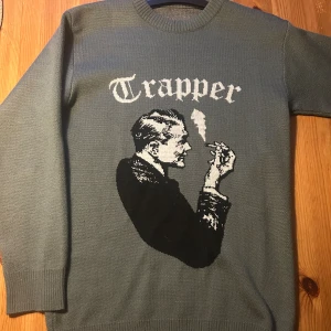 Grå stickad tröja med Trapper-tryck - Stickad tröja från Made from trappers.                                 Bara att skriva om man vill se fler bilder.                    Pris kan diskuteras!!!