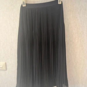 Mörkblå  plisserad kjol från H&M - Mörkblå plisserad kjol från H&M med elastisk midja. Knappt använd storlek xs