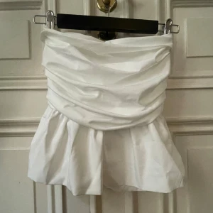 Vit bandå-topp med volang - Jag säljer min super snygga bandå-topp med volang!! Den är så bekväm och såå snygg!! Köpt för 449 kr men säljer för endast 290kr!!💗💗💗