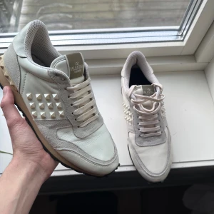 Valentino Rockrunner  - Snygga Valentino Rockrunner sneakers i beige och grått med nitar på sidorna. Skorna har snörning, rund tå och platt sula. Materialmix av skinn och mocka med meshfoder för extra komfort. Perfekt för dig som gillar exklusiva och unika sneakers. Pris kan diskuteras! Skick - 8/10.