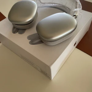 AirPods Max - Apple AirPods Max i silver, over-ear hörlurar med aktiv brusreducering. Mycket fint skick, ser oanvända ut med skyddsplast kvar på bygeln och originalförpackning. Perfekt för högkvalitativ musik och samtal.