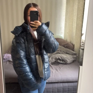 Mörkblå pufferjacka med dragkedja - Snygg mörkblå pufferjacka med hög krage och dragkedja framtill. Änvendes förra vintern. Passar som M