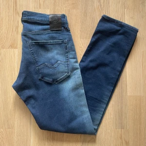 Mörkblå Replay Waitom jeans W31 L34 - Jag säljer dom här riktigt snygga Replay Waitom Jeansen som är i storlek W31 L34. De är knappt använda och är i fint skick utan skador och defekter. Tveka inte att höra av er!                        Mått: Längd=107cm. Midja=41cm