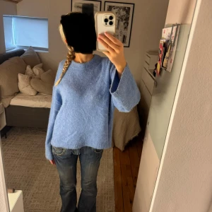 Ljusblå stickad tröja med loose fit - Mysig ljusblå stickad tröja.. Modellen är loose fit och har ribbade muddar vid ärmslut och nederkant. Storlek S.