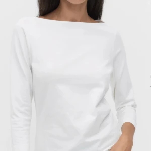 Vit topp  - Säljer en stilren vit topp från Stockh lm med lång ärm och rak, bred halsringning. Toppen är gjord i mjuk bomull och har en clean, minimalistisk look som är enkel att matcha. Perfekt för dig som gillar basic och tidlös design. Skriv för bild på toppen. Den har aldrig kommit till användning så är i topp skick.