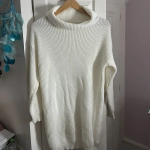 Vit stickad polotröja i oversized modell - Mysig vit stickad polotröja med bred, ribbad krage och lång ärm. Tröjan har en oversized passform och är perfekt för kyliga dagar. Enkel och stilren design som passar till många olika outfits, ta hjärna ett bälte eller nått som gör att du kan designa den som en klänning också.💗 Den är varm och bekväm, andvänt endas när jag fick hem den vid köp av digitalt ‼️