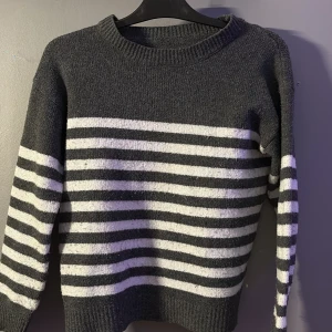 Randig stickad tröja i grått och vitt - Mysig stickad tröja med breda ränder i grått och vitt. Tröjan har rund halsringning, ribbade muddar och lång ärm. (skulle säga att den är lite stor i storleken) (den är från shein, därav priset.) den har som små ”knottror” på den oxå. men de är inget jag själv skulle tänka på.❣️