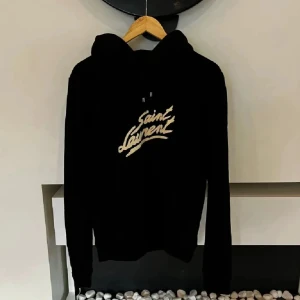 Saint Laurent hoodie - Säljer min feta Saint Laurent hoodie för ett sjukt bra pris. Perfekt nu till höst/vinter och den passar till alla möjliga outfits. Skick 9/10. Hör gärna av er om ni har några funderingar eller vill diskutera pris!