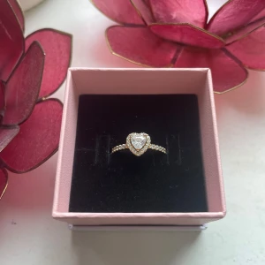 Pandora ring - Ring i guld från Pandora med upphöjt hjärta. Mätte innerdiametern till 17 mm så det borde vara storlek 54 men är osäker. Använd men inga synliga defekter. Nypris 999 kr.