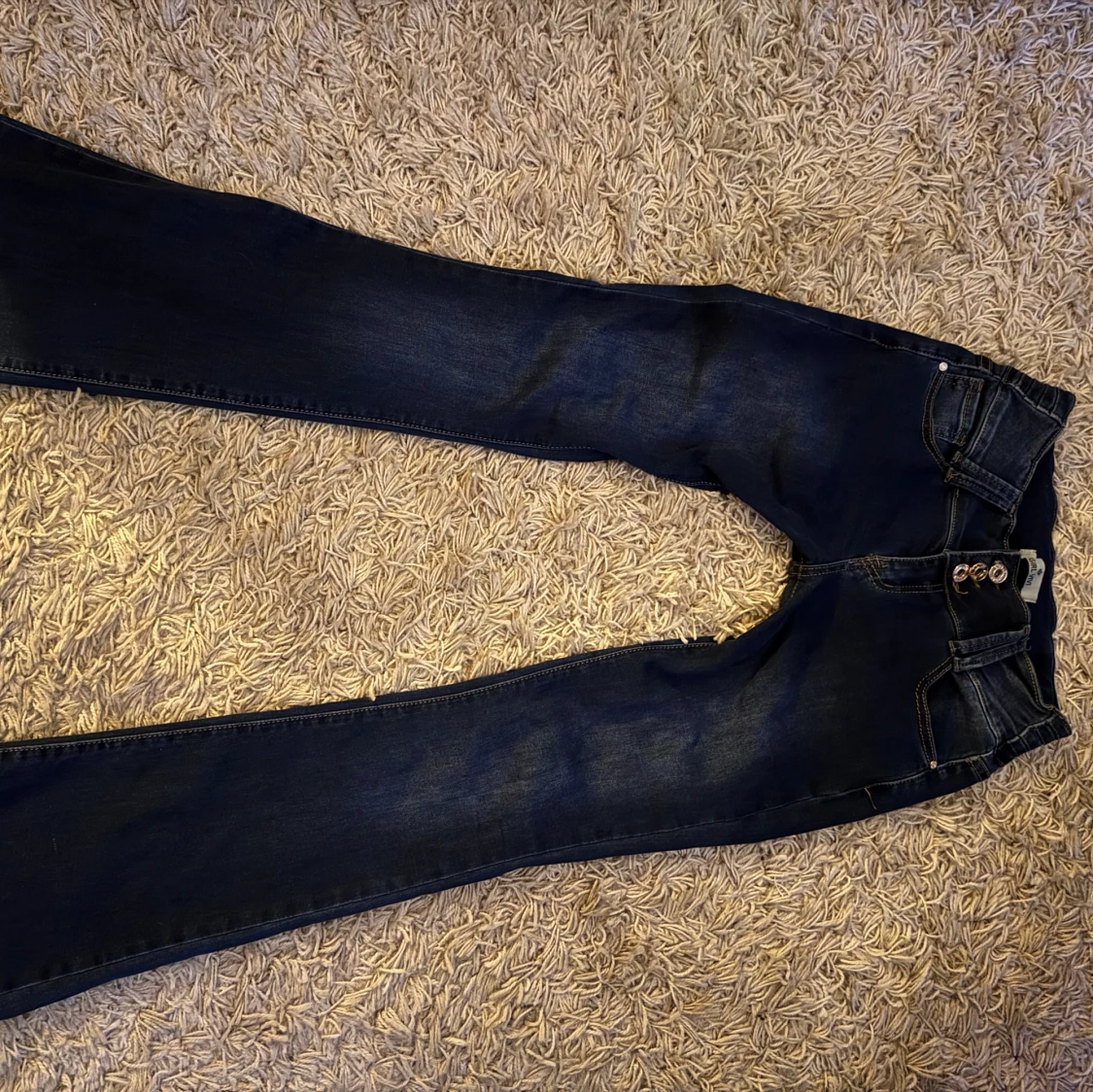 Mörkblå lågmidjade/utsvängda jeans med tre knappar - 1