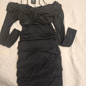 Svart omlottklänning Marciano Guess - Supersnygg svart omlottklänning från Marciano by Guess med långärmade offshoulder-ärmar och smala axelband. Klänningen är helt ny med prislapp. Nypris 3000 kr💕