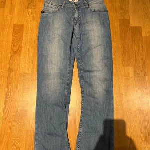 Blå jeans från Tiger of Sweden - Snygga blå jeans från Tiger of Sweden med klassisk femficksdesign och raka ben. Jeansen har en ljus tvätt och subtila slitningar framtill. Nypris runt 2000kr vårt pris 329kr en super deal!!!😮‍💨😮‍💨💯💯W29 L32
