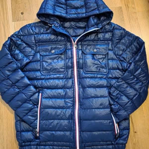Moncler Douret dunjacka - Säljer min blå Moncler Douret jacka med huva. Jackan har två bröstfickor med knappar och två sidofickor med dragkedja. Jackan har en liten defekt på dragkedja men syns inte jätte tydligt.