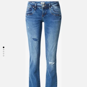 Jeans valerie LTB - Säljer ett par blå bootcut jeans från LTB med slitna detaljer och snygga slitningar på benen. Jeansen har låg midja, klassiska fem fickor och kontrastsömmar. Materialet är jeans med en skön stretch och passformen är loose med bootcut nedtill.