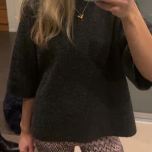 Mörkgrå stickad tröja från 157 - Säljer en mörkgrå stickad tröja från 157 med rund hals och halv-långa ärmar. Modellen är loose fit och har en enkel, clean look som är lätt att styla. Perfekt för dig som gillar chill och oversized vibe.