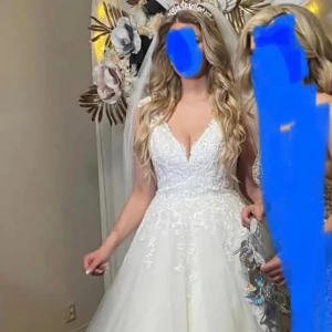 Vit Crème bröllopsklänning f. Ladybird - Superfin vit bröllopsklänning från Ladybird med v-ringning och spetsdetaljer upptill. Klänningen har en lång, vid kjol i flera lager och vackra broderier på livet. Ärmlös modell med markerad midja och klassisk siluett. Perfekt för dig som vill ha en romantisk look.kom gärna och prova i norsborg botkyrka.(stockholm)