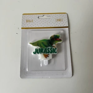Jurassic Dinosaur Candle - Rolig dinosaurieformad ljusdekoration med 'Jurassic'-text, perfekt för barnkalas eller temafest. Produkten är ny i originalförpackning.