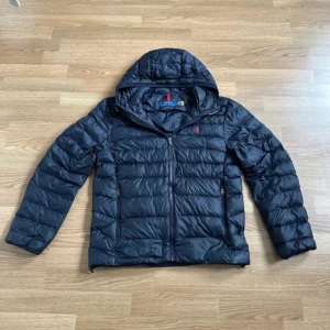 Ralph lauren jacka - Hej! Jag säljer nu min Ralph lauren jacka som är sjukt snygg och passar perfekt till dagar där det är mellan 0-15+ grader. Köpt nu i våras men jag säljer den då jag tycker att den är något kort i armarna på mig. Passar dig som är mellan 165- 175. Inga synliga tecken på användning så man skulle kunna tro att den är helt ny. Jackan är även 100% äkta som man kan se med hjälp av qr-koden på bild 4 och 5. Nypris ca 4000kr. Hör av dig vid minsta lilla fundering!