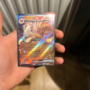 Ninetales ex Pokémon Card (Japanese, 038/165 SV6a) - Sällsynt Ninetales ex holografiskt Pokémonkort på japanska, i mycket fint skick och skyddad i sleeve. Kortet har vacker foil och tydliga färger, inga synliga skador eller slitage. Perfekt för samlare eller spelare som vill utöka sin samling med en exklusiv karta.