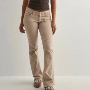 Beiga bootcut manchesterbyxor - Snygga beiga manchesterbyxor med bootcut passform och låg midja från Nelly. Storlek 34.