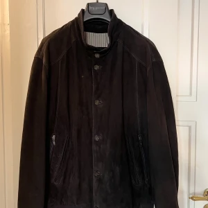 Vintage Mockajacka  - Svart mockajacka med dragkedja och knappstängning. Jackan har en ribbad mudd nedtill och vid ärmslut. Storlek L men passar även M