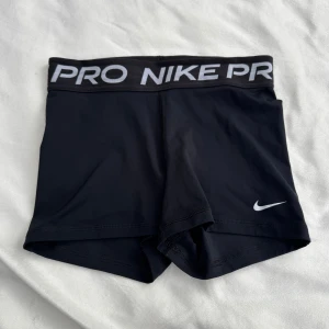 Nike Pro träningsshorts  - Svarta Nike Pro shorts, tight passform & korta ben. Materialet är mjukt och stretchigt. Lappen är bort klippt (se bild) då den irriterade, använda men fina. I storlek S. Fraktar inom 24h!