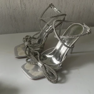 Silvriga klackskor med diamanter på - diamanterna sitter fortfarande på perfekt men skorna är för höga för mig så kan inte längre gå i de (12 cm hög)