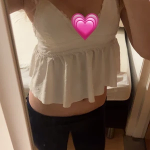 Vit volangig linnetopp med spets - Söt vit linnetopp med volang nertill och spetsdetaljer vid axelband och byst. Toppen är ärmlös och har en v-ringad skärning. är i storlek M men sitter som en S säljer för den har blivit liten💗