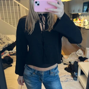 Svart kofta med snörning - Säljer en svart, stilren kofta med snygg snörning framtill som går upp mot halsen. Den har även vida ärmar som adderar en fin, trendig look 🫶🏼Koftan är oanvänd och passar XS och S!