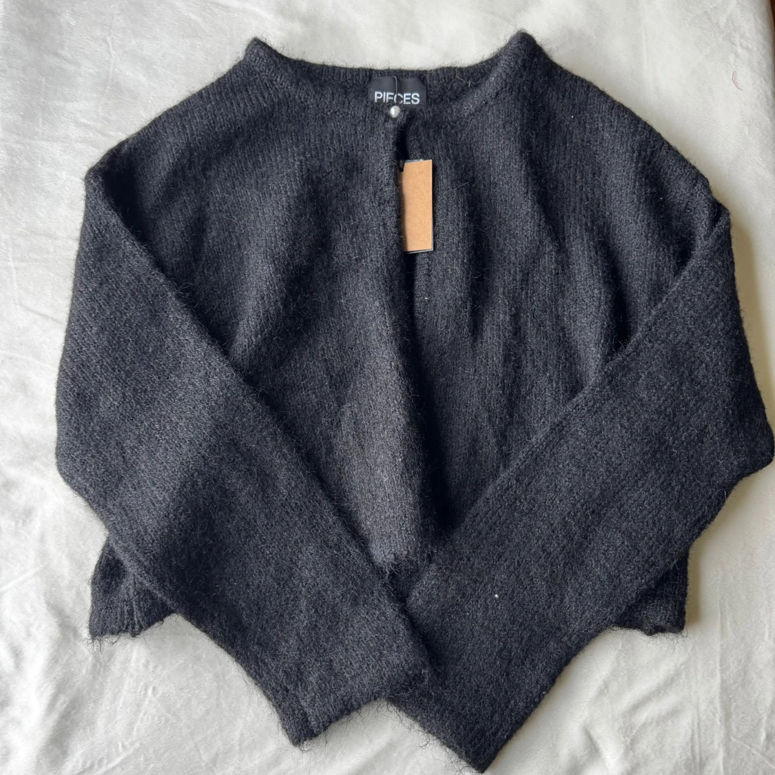 Svart kofta med pärlknapp