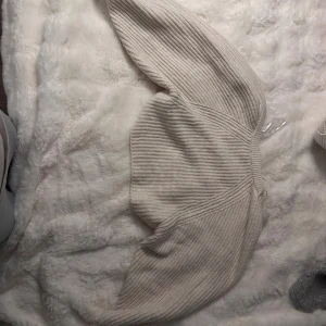 Beige ribbad bolerotopp - Säljer en beige stickad bolerotopp från Lindex . Toppen är ribbad och har långa ärmar. Perfekt att slänga över ett linne eller klänning för en trendig lager-på-lager-look.