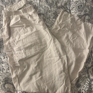Beige- och vitrandiga pyjamasbyxor  - Pyjamasbyxorna kommer från Kappahl och är i storlek S. Jag köpte dessa förra sommaren. De är i super fint skick🤎
