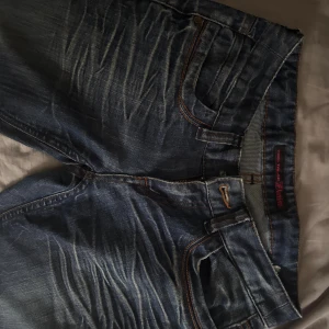 Jeans  - Säljer ett par as snygga jeans som jag inte vet vilket märke det är tyvärr. Knappen har ramlat av men på verkar inte funktionen på jeansen. Passar mig i längden som är 172cm. Mått: Innerbenslängden: 75  Ytter benlängden: 98,5  Midjemått: 35