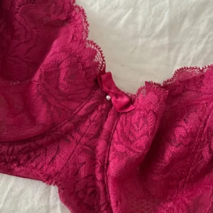 Bh balconette - Fin balconette bh med pärla, rosett och spets design!! Storlek 65G, mörk rosa färg. Köpt i butik för 800 kr. Säljer då den ej kommit till användning ❤️