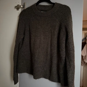 Mörkgrön stickad tröja från Pieces - Mysig mörkgrön stickad tröja från Pieces i storlek L. Tröjan har rund hals och långa ärmar, med en lite loose passform som gör den extra skön. Perfekt för kyliga dagar och enkel att matcha med jeans eller leggings.