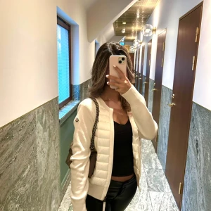 Vit cardigan jacka från Moncler - OBS: PRIS KAN DISKUTERAS. Säljer en snygg vit cardigan jacka från Moncler med quiltad framsida och två fickor. Jackan har långärmade stickade ärmar, rund hals och dragkedja framtill. Perfekt för dig som gillar stilrena och exklusiva plagg med en modern touch.