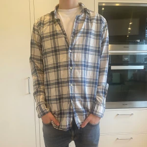Rutig skjorta från Massimo Dutti - Riktigt snygg rutig överskjorta från Massimo Dutti i vitt och blått. I storlek M. Tröjan har inga tecken på användning och är i perfekt skick. Har du några frågor kring mått osv? Fråga på! 
