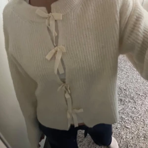 Beige stickad kofta med rosetter - Superfin beige stickad kofta från Gina tricot med tre söta rosetter framtill. Perfekt att slänga på sig över ett linne eller t-shirt!  Kommer inte till användning tyvärr. Pris kan diskuteras 💙