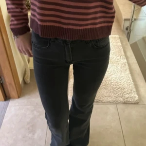 Svarta bootcut jeans - Säljer ett par svarta jeans med bootcut-snitt och klassisk femficksdesign. Jeansen har en mörk ton och är tillverkade i ett mjukt denim-material som sitter snyggt över höfterna och har lätt utsvängda ben. Perfekta för dig som gillar en tidlös och cool look.