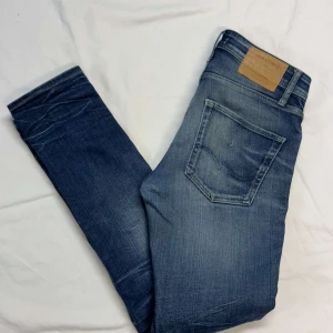 Blå slim fit jeans från Jack & Jones - Snygga blå slim fit jeans från Jack & Jones. De har en klassisk femficksdesign, en lätt tvättad look med slitningar som ger en avslappnad stil. Perfekta för en casual outfit. Strl 30/34, model slimfit tim 