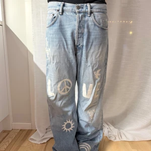LIMITED EDITION Acne Studios ljusblå wide jeans 29/32 - Unika ljusblå jeans från Acne Studios med bred passform och coola vita tryck med symboler och text. Loose fit
